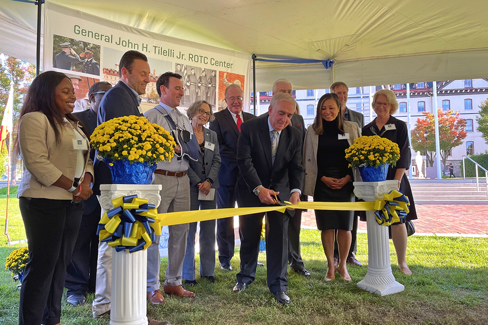 General John Tilelli cuts a yellow ribbon while surrounded by Trustees during the R-O-T-C naming dedication