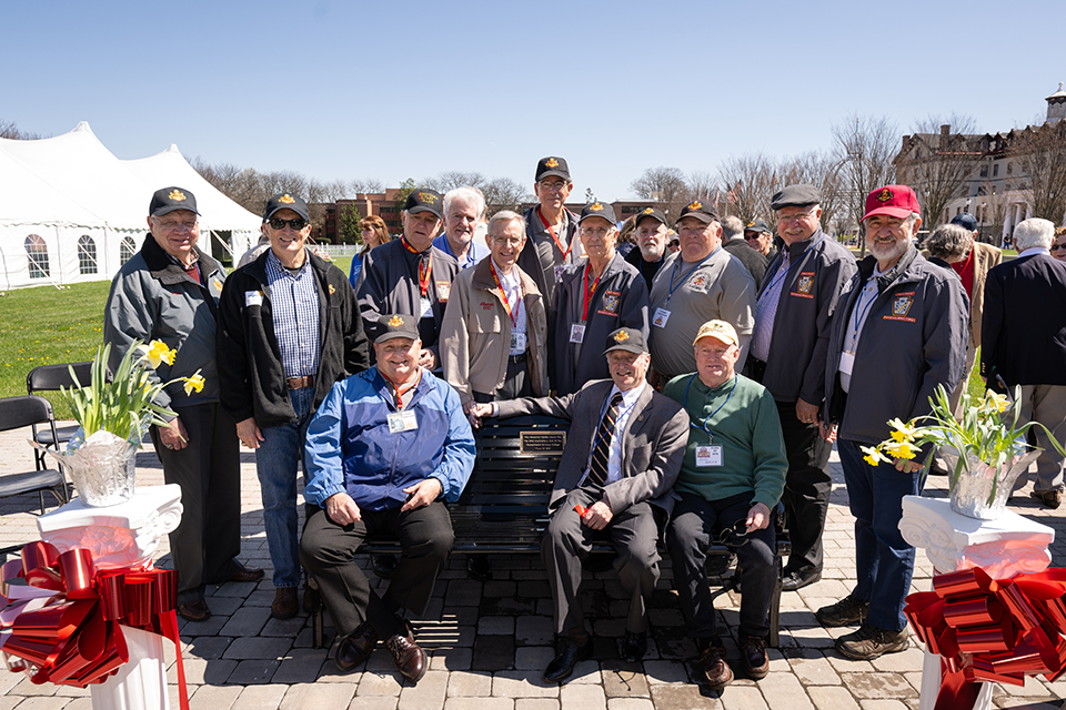 Alumni gather around a bench on campus that was dedicated during the Founders Day celebrations.