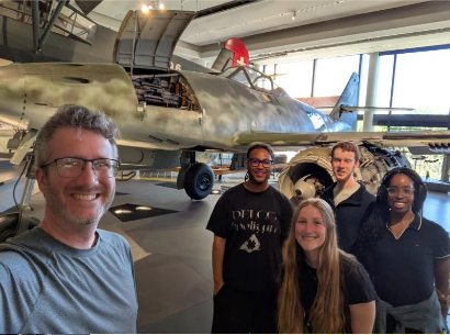 Widener faculty and students pose for a photo at a museum. 