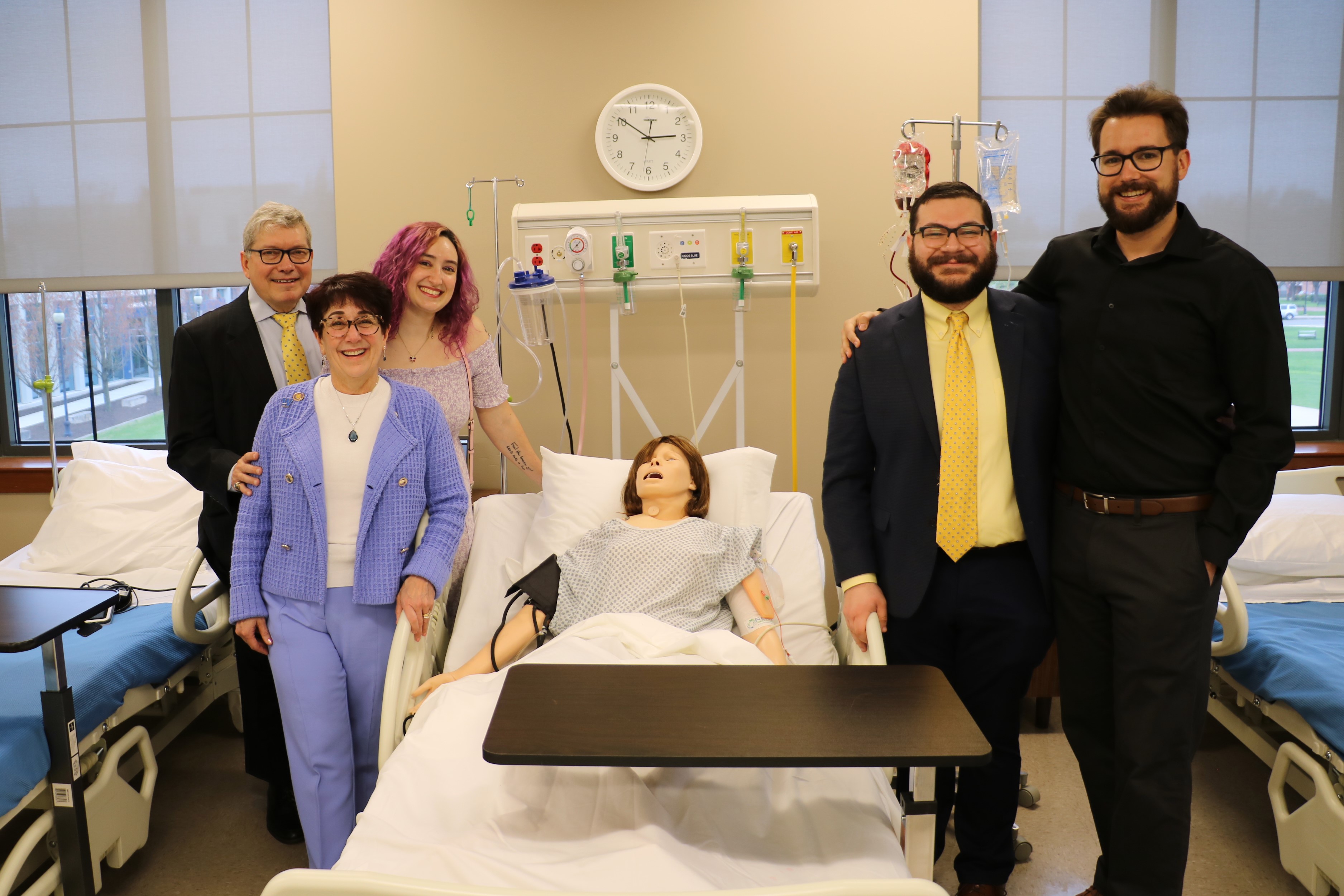 Marietta and Mike Borinski stand on the left and pose with their family and a sim mannequin at the lab's dedication event.