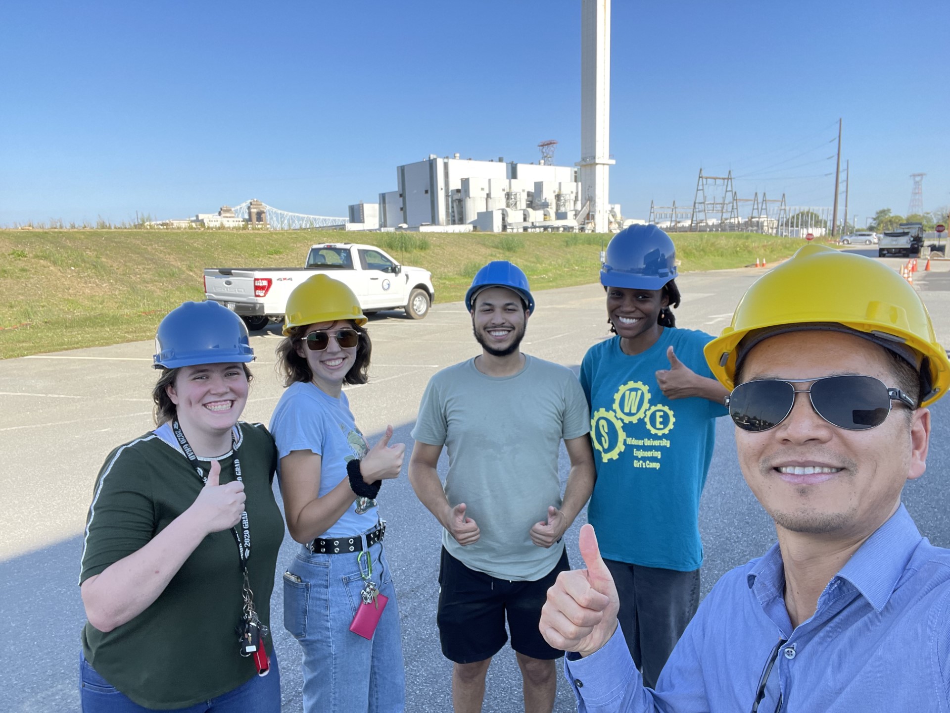 Professor Tang wearing hard hats with a group of students