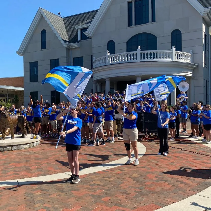 The marching band performs at the Pride statue at convocation