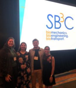 Undergraduate students pose in front of the conference welcome sign.