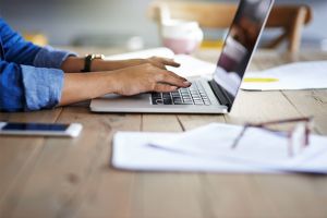 Person typing on computer from home