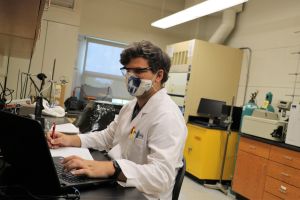 Student wearing mask works in chemistry lab