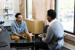 A clinical counselor speaks with his client.