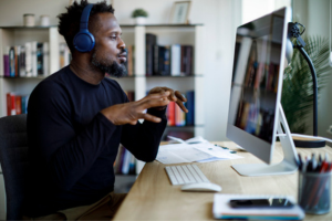 A male student meets virtually with a professor.