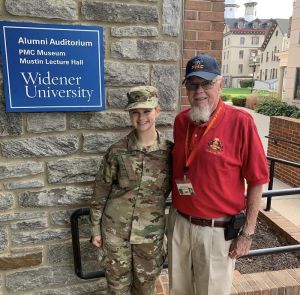 PMC alum stands with his granddaughter wearing military fatigues who is in Widener's ROTC program