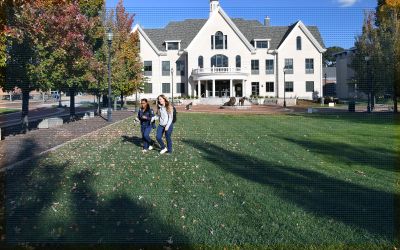 Two undergraduate nursing students walking across campus in fall