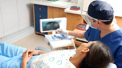 A dental student examines a patient.