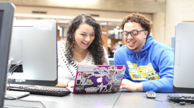 Two students work together on a laptop while exploring ideas and projects in Widener University's AI major.