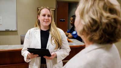 widener school of nursing graduate student wearing lab coat works in simulation lab near philadelphia