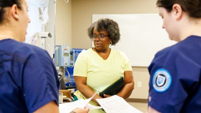 widener school of nursing professor teaches two undergraduate students in simulation lab near philadelphia