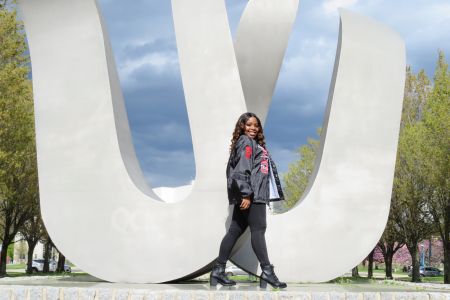 Student Ijjae Hill stands in front of the 'W' statue