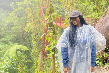 Naomi Knight poses in the rainforest wearing a poncho