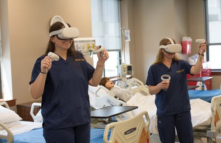 Female nursing students wear oculus headsets to practice in virtual simulated clinical settings.