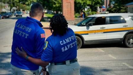 Two campus safety officers with their backs to the camera and pointing off to the distance.
