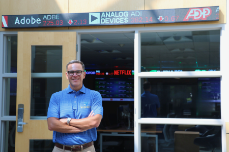 Cary Caro poses in front of the university's finance lab