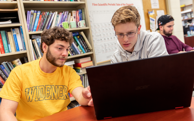 Two Widener students seated, working on a laptop-based assignment together