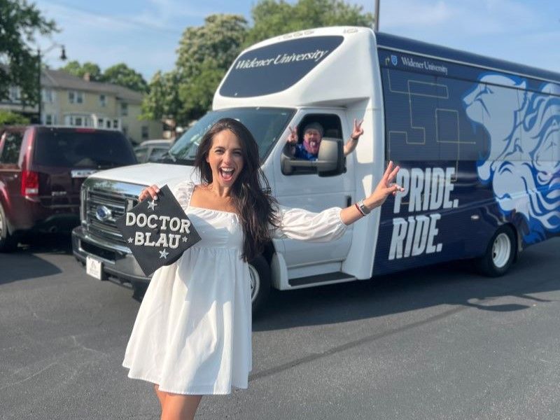 Human sexuality studies graduate Carli Blau poses with her graduation cap that says "Doctor Blau" along with the Pride Ride driver